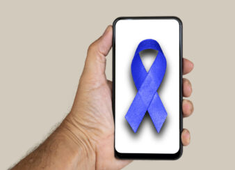 mão segurando um celular com o símbolo novembro azul