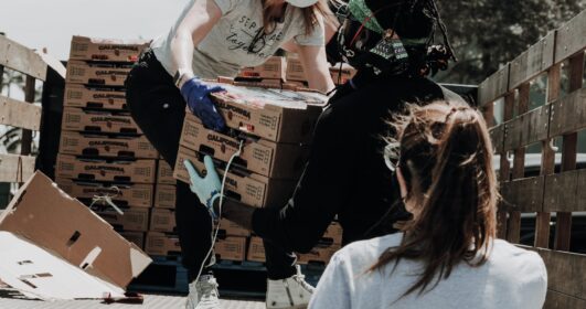 Voluntários auxiliando na distribuição de alimentos.