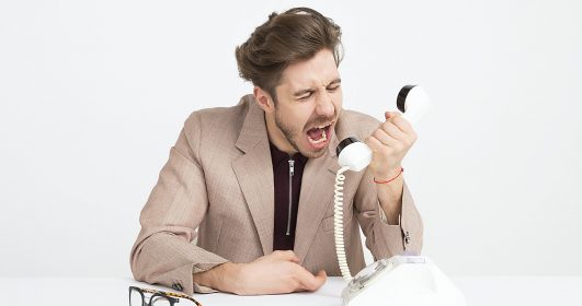Imagem de um homem gritando no telefone.