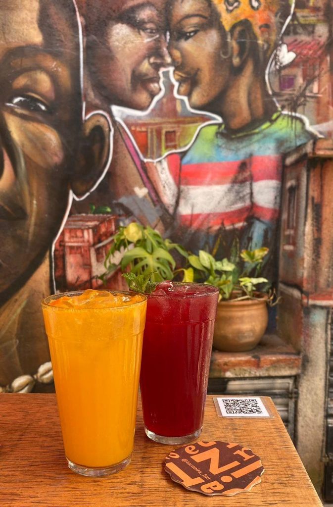 foto de bebidas nas cores laranja e vermelho. com um graffiti ao fundo. 