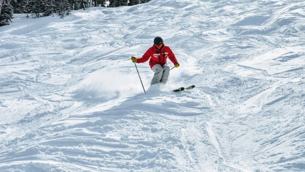 uma pessoa usando roupa vermelha esquia na neve.