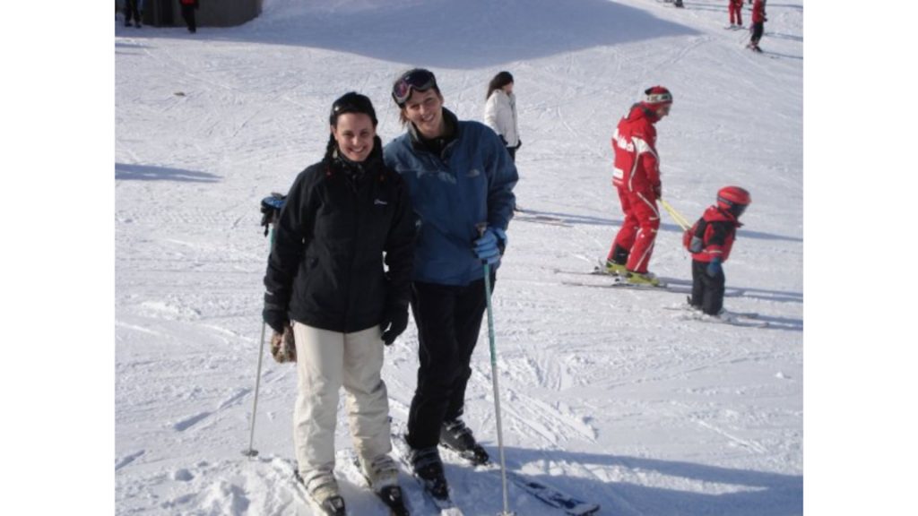duas mulheres posam para uma foto em uma área de esquí. 
