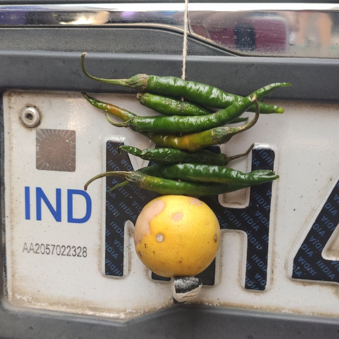 limão e pimenta amarrados na placa de um carro. índia